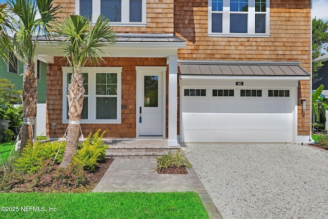 142 Ocean Blvd, Atlantic Beach, FL 32233 - view of exterior entry with a standing seam roof, driveway, a garage, and a metal roof