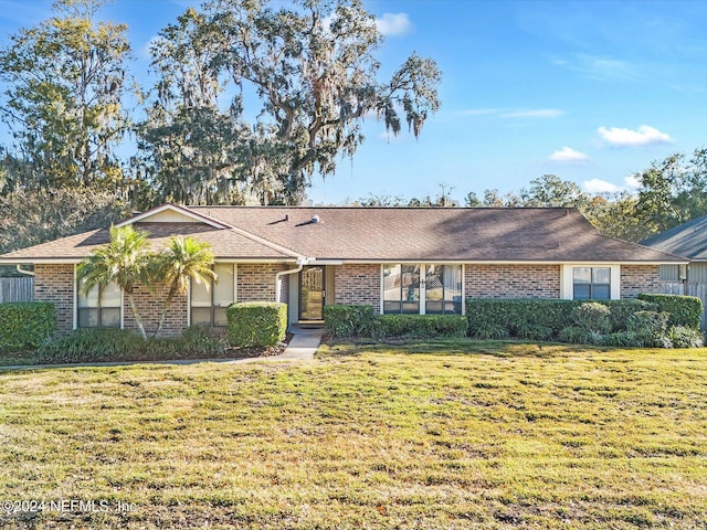 single story home featuring a front lawn