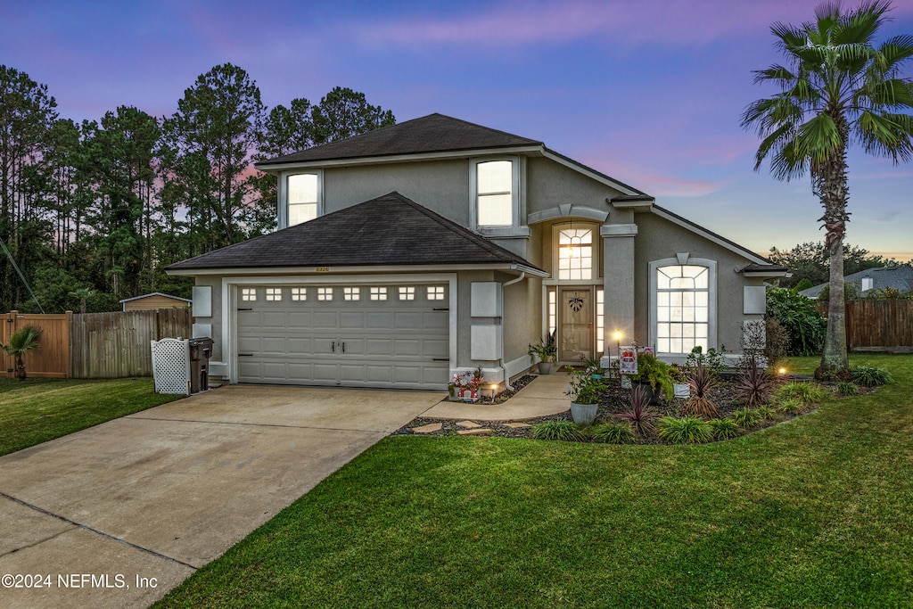 front facade featuring a lawn and a garage