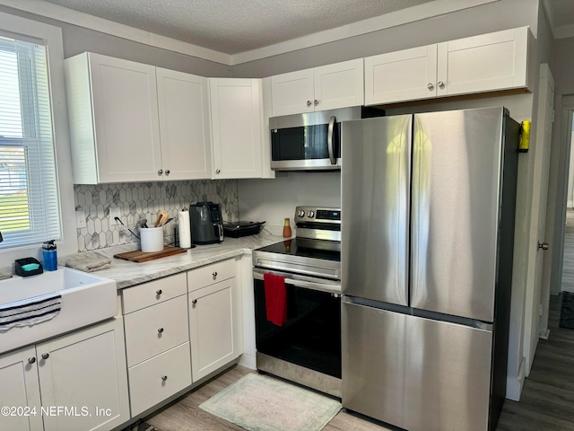 kitchen featuring light hardwood / wood-style flooring, white cabinets, and stainless steel appliances