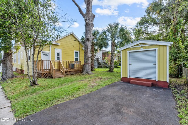 view of front facade featuring a front yard, an outbuilding, and a deck