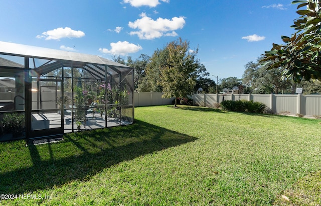 view of yard featuring a patio and a lanai