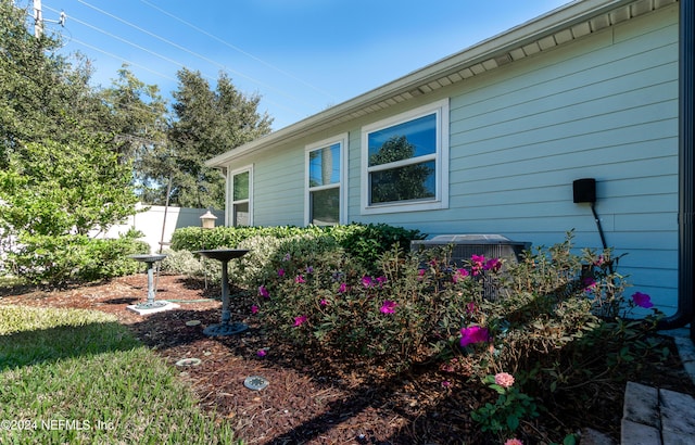 view of side of home with central AC unit