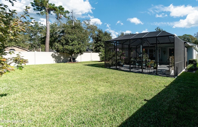 view of yard with glass enclosure and a patio area