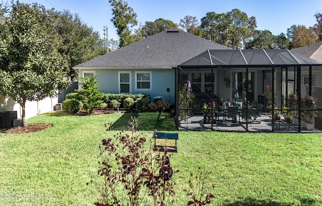 back of house with a lanai, a lawn, and a patio