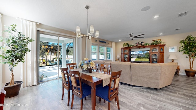 dining space with a textured ceiling and ceiling fan with notable chandelier