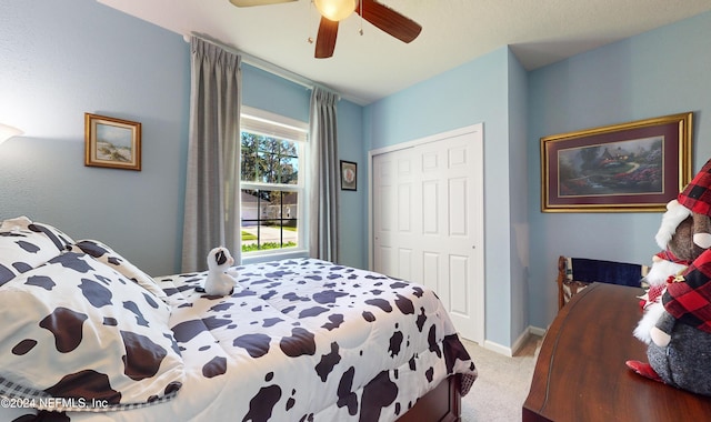 bedroom featuring ceiling fan, a closet, and light colored carpet