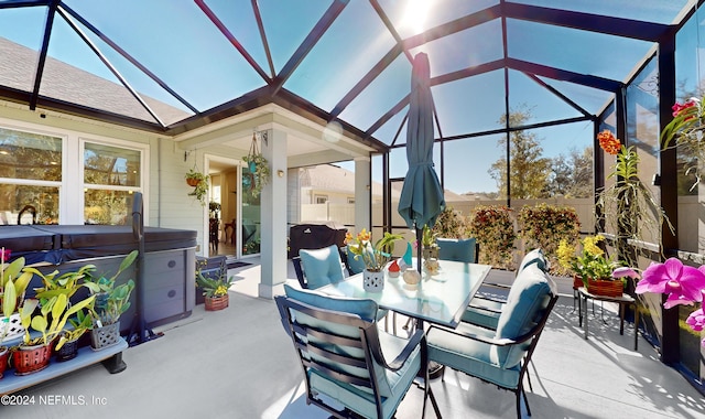 view of patio / terrace featuring glass enclosure and a hot tub