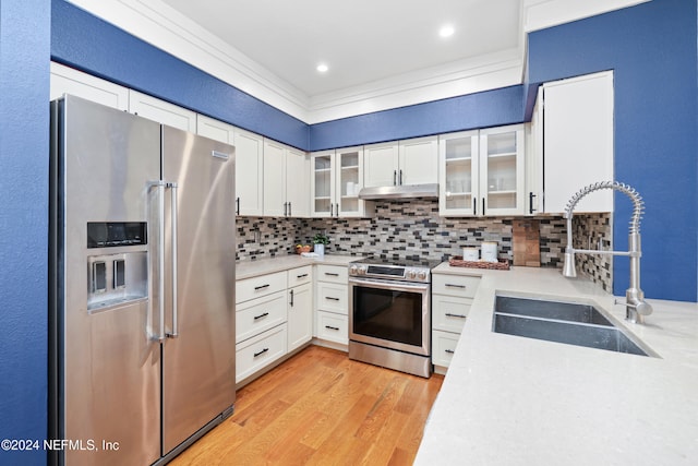 kitchen featuring white cabinetry, sink, stainless steel appliances, backsplash, and light hardwood / wood-style floors