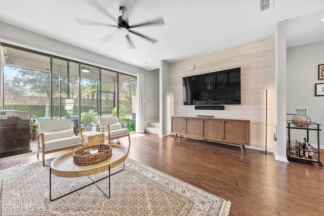 living room featuring ceiling fan and dark wood-type flooring