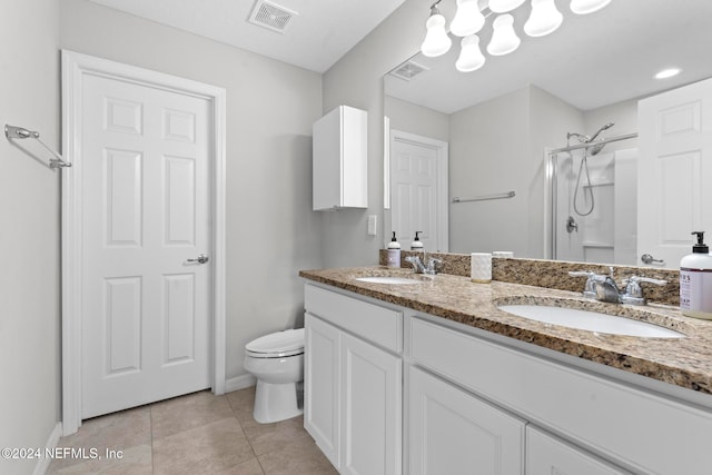 bathroom featuring tile patterned floors, toilet, vanity, and walk in shower