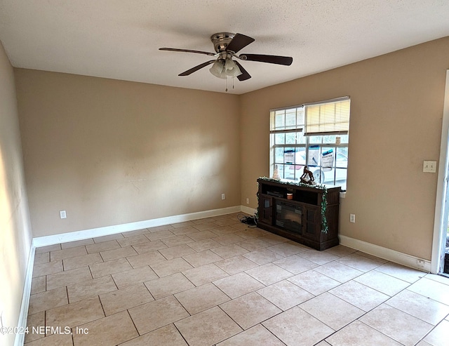 unfurnished living room featuring a fireplace, a textured ceiling, and ceiling fan