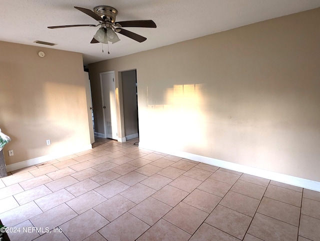 tiled empty room featuring a textured ceiling and ceiling fan