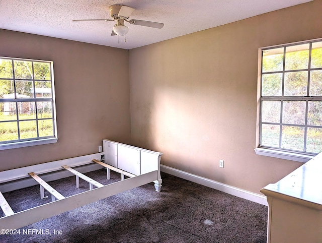 unfurnished bedroom featuring multiple windows, ceiling fan, and carpet floors