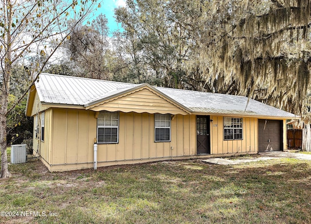 view of front of house with a front yard and central air condition unit