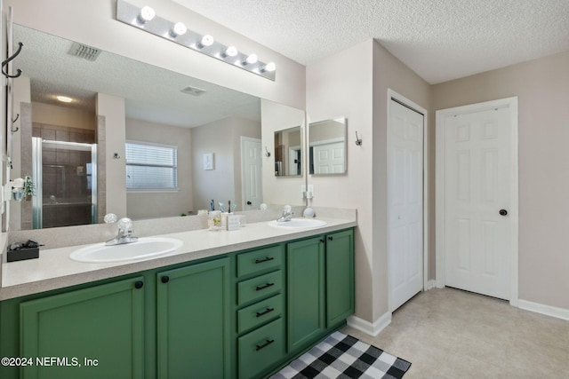 bathroom featuring vanity, a textured ceiling, and walk in shower