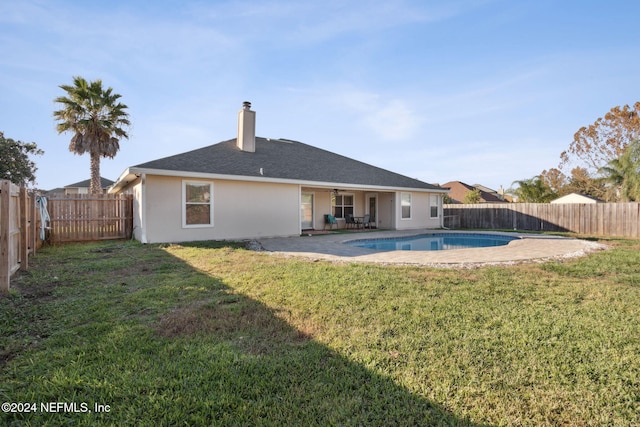 rear view of property with a fenced in pool, ceiling fan, a yard, and a patio