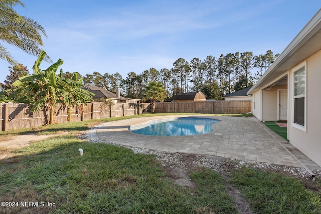 view of swimming pool featuring a lawn and a patio