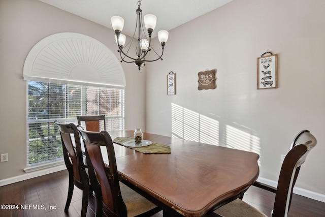 dining space featuring dark hardwood / wood-style flooring and an inviting chandelier