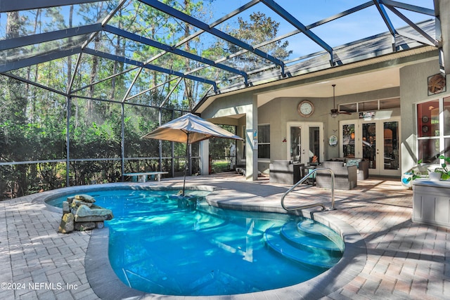 view of pool featuring french doors, a patio, glass enclosure, and ceiling fan