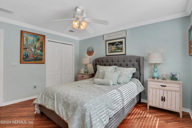 bedroom with ceiling fan, a closet, crown molding, and dark hardwood / wood-style floors