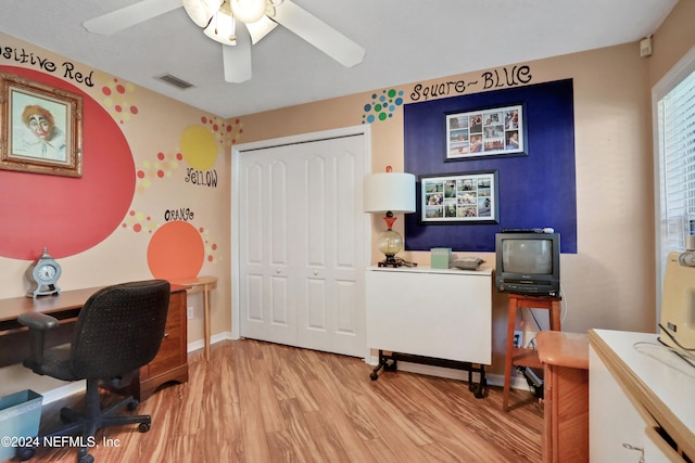 office with light hardwood / wood-style flooring and ceiling fan