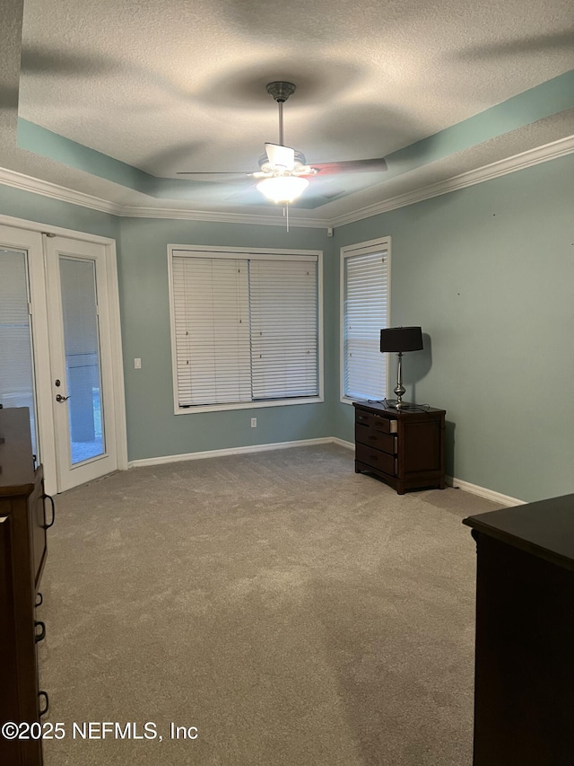 unfurnished bedroom with light carpet, french doors, a textured ceiling, a raised ceiling, and ceiling fan