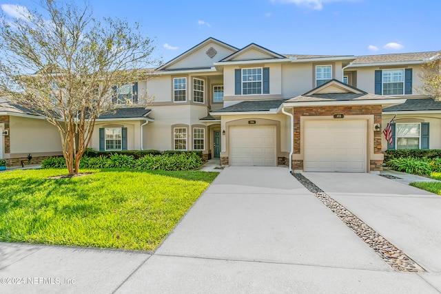 townhome / multi-family property featuring a front yard and a garage