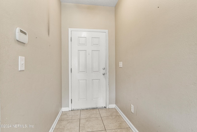 entryway featuring light tile patterned flooring and a textured ceiling