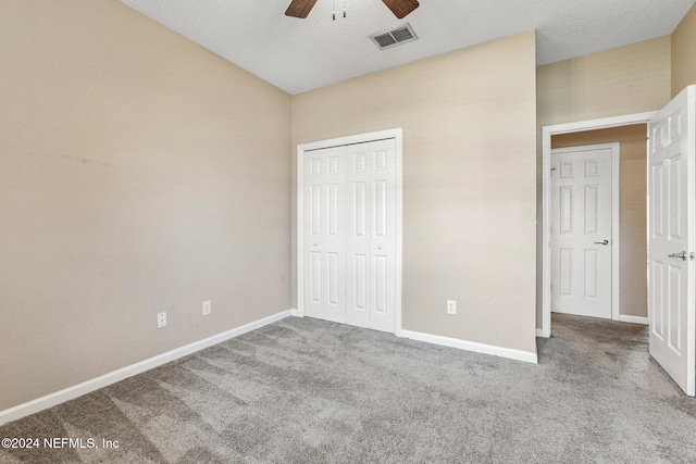 unfurnished bedroom featuring carpet flooring, ceiling fan, a textured ceiling, and a closet