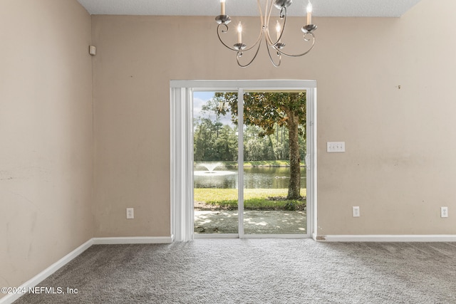 unfurnished dining area with carpet flooring, a textured ceiling, and a notable chandelier