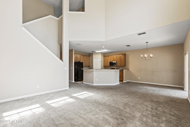 unfurnished living room featuring light colored carpet, a high ceiling, and an inviting chandelier