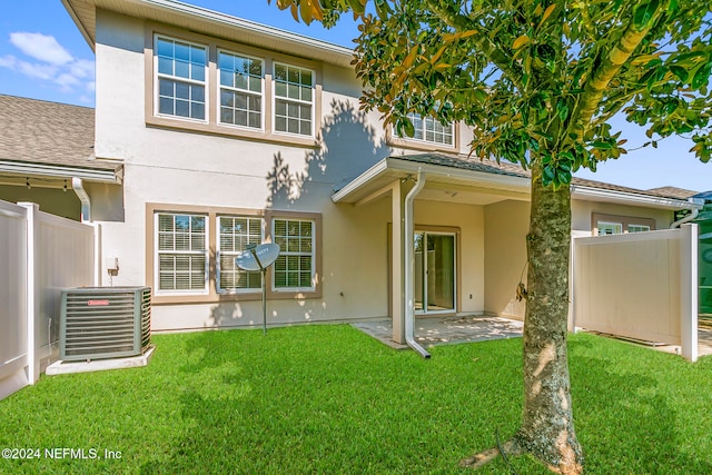 rear view of property featuring a patio area, a yard, and central AC unit