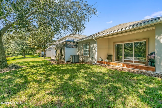 back of house with cooling unit, a lanai, and a lawn