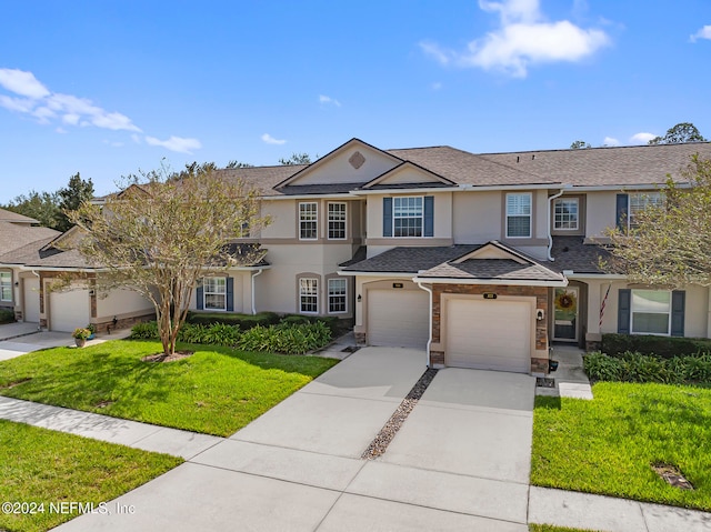 view of front of property featuring a front yard and a garage