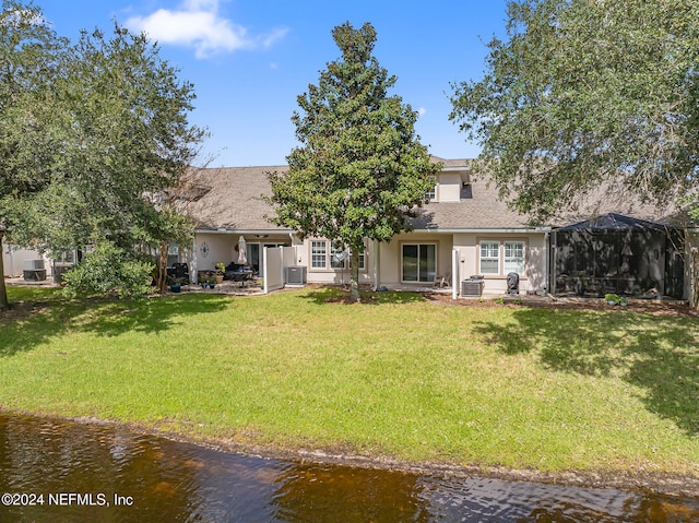 rear view of property featuring a lawn and a water view