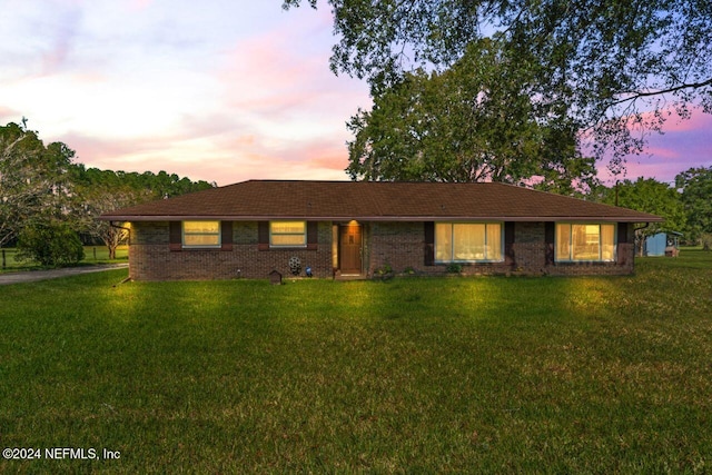 ranch-style home with a yard