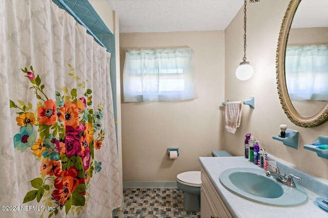 bathroom with walk in shower, a textured ceiling, vanity, tile patterned flooring, and toilet