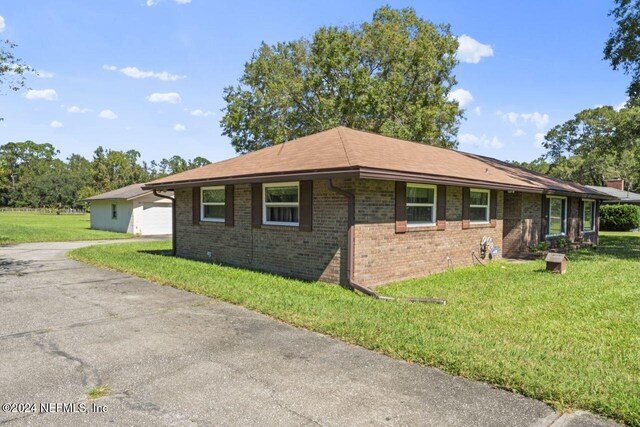 view of side of home with a yard and a garage