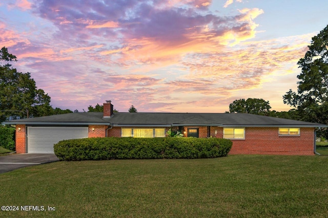 ranch-style home with a lawn and a garage