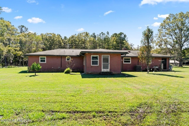 back of house featuring a yard and central air condition unit