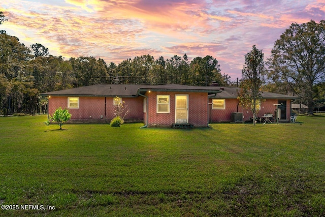 ranch-style house featuring a yard and central AC unit