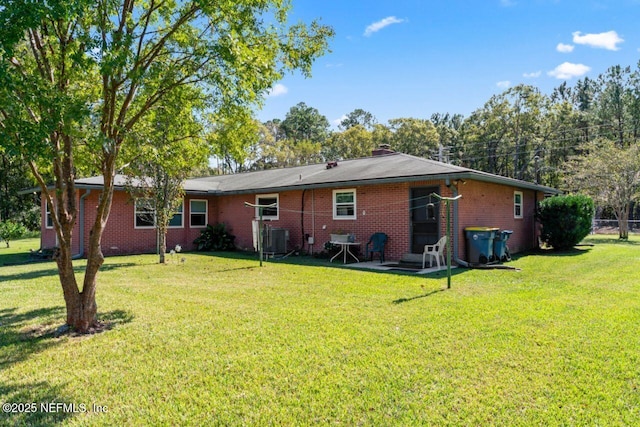 back of property featuring central air condition unit and a lawn