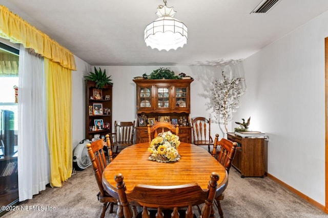 dining area featuring light carpet