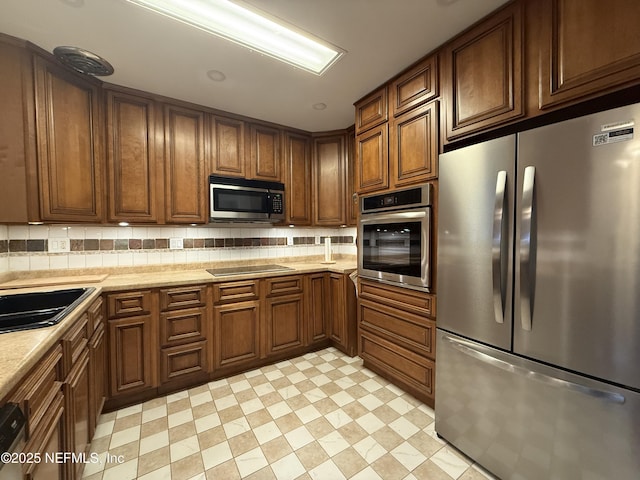 kitchen featuring decorative backsplash, sink, and stainless steel appliances