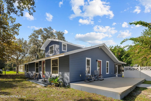 back of property with a lawn and covered porch