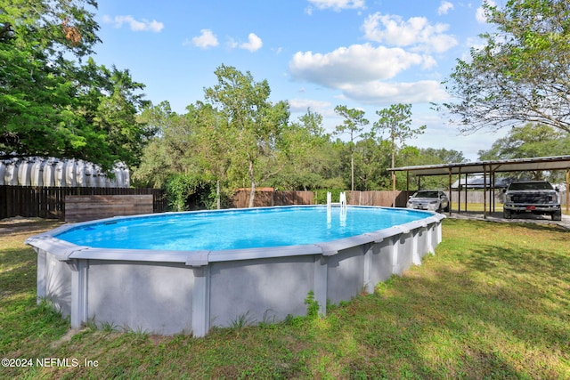 view of swimming pool featuring a yard and a carport