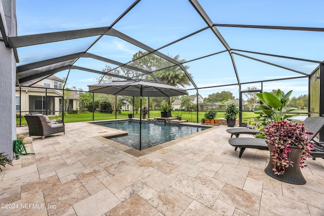 view of pool with a lawn, glass enclosure, and a patio area