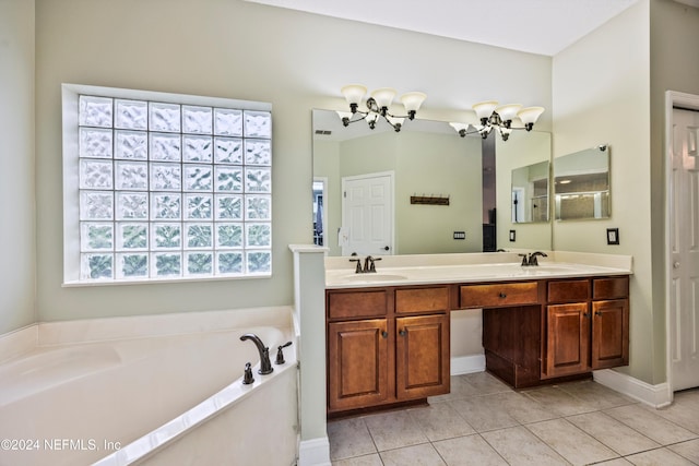 bathroom with a washtub, vanity, and tile patterned flooring