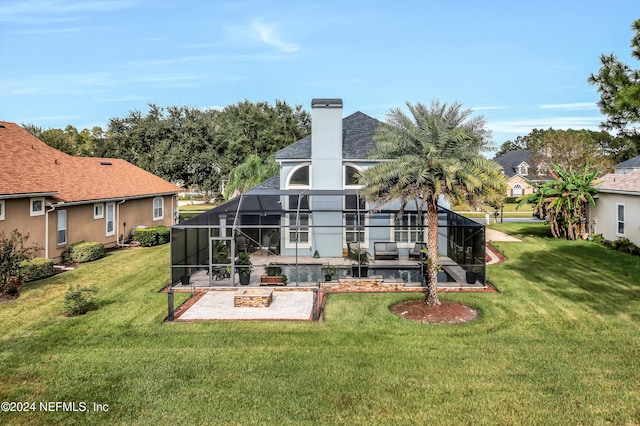 rear view of house with a lawn, glass enclosure, and a patio